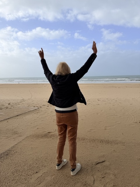 nach einem erfolgreichen Sturzprophylaxe Training freut sich diesen Seniorin, wieder am Meeresstrand zu stehen